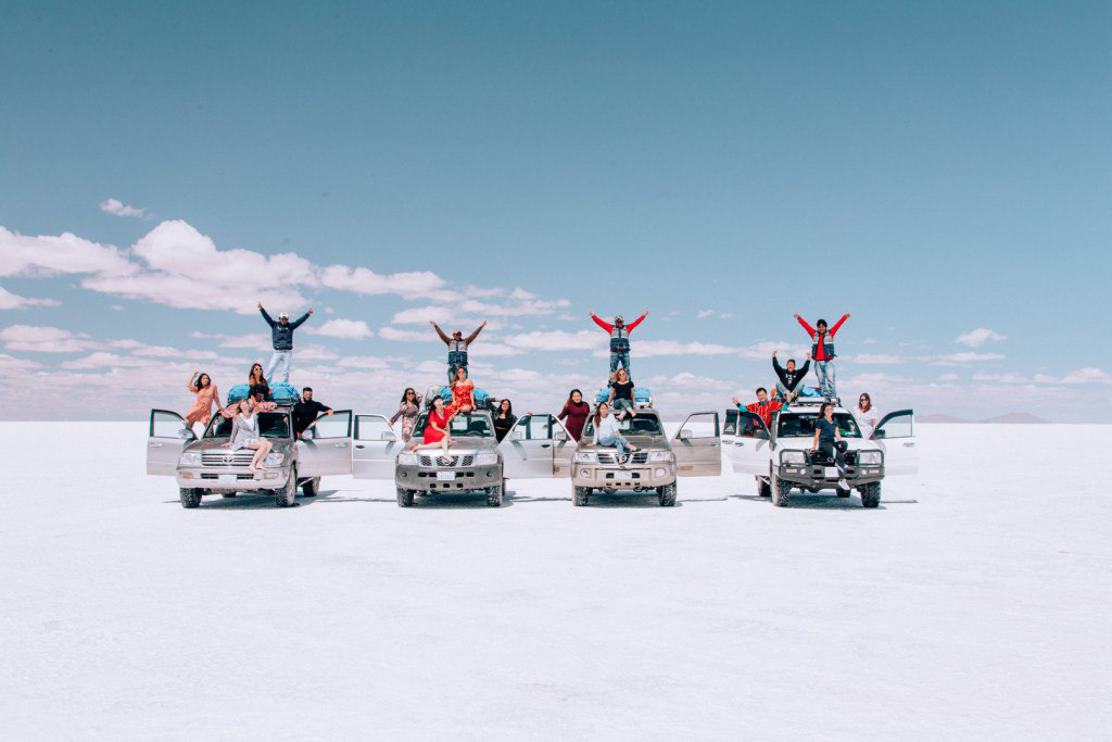 Туристы на четырех внедорожниках позируют перед камерой Поездка на джипах по Салар де Уюни